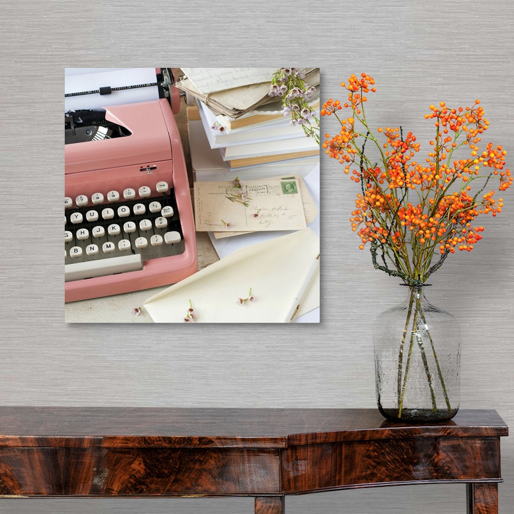A traditional room featuring A pink typewriter surrounded by old books, letters and dried flowers in this square shaped, decor...