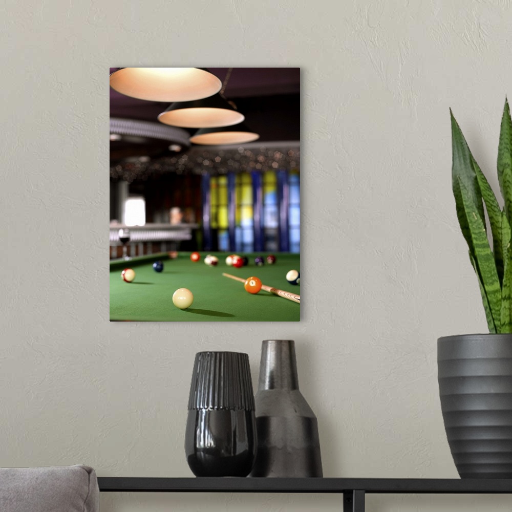 A modern room featuring Pool table and glass of wine.