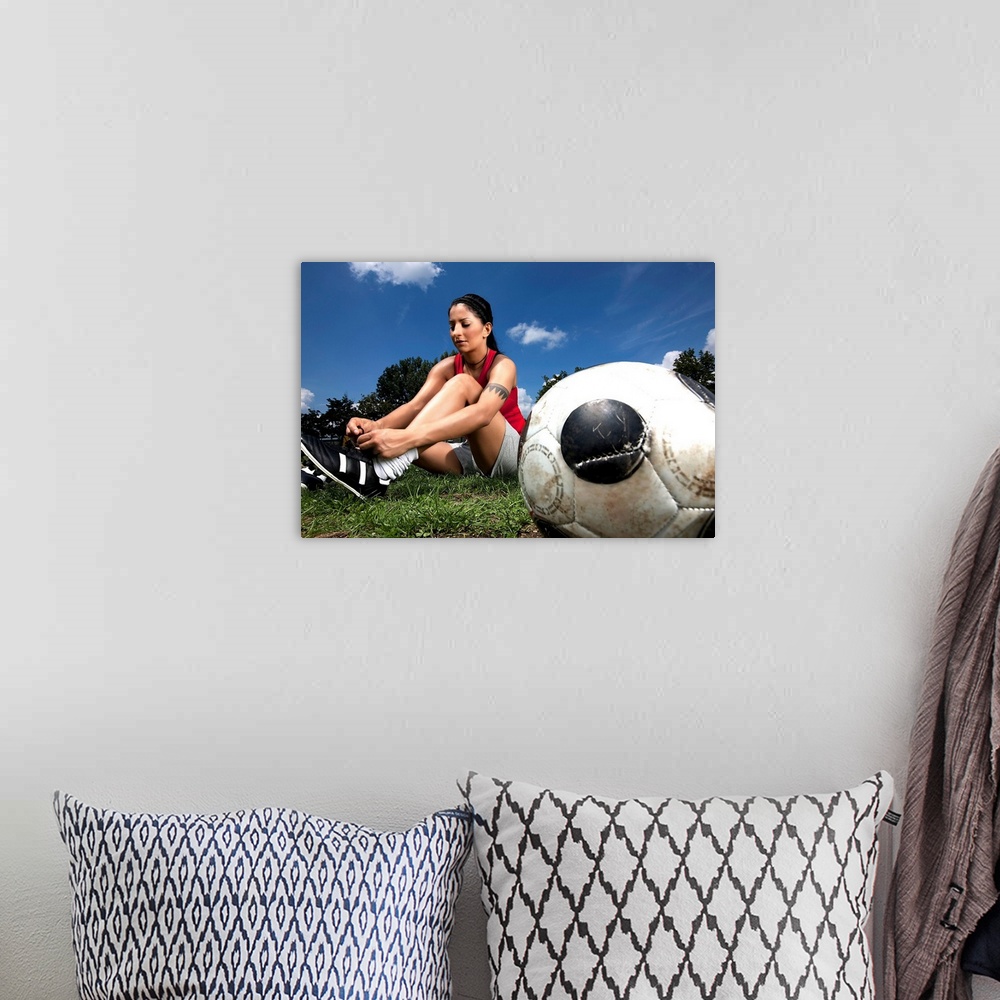 A bohemian room featuring Portrait of female football player tying her shoes
