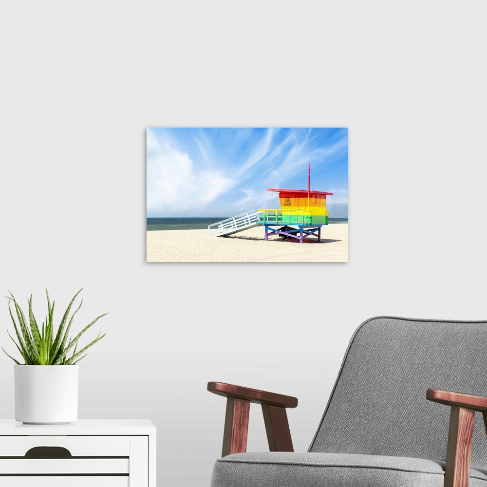 A modern room featuring A vibrant photo of a lifeguard tower in the colors of the pride flag, located at Venice Beach, Lo...