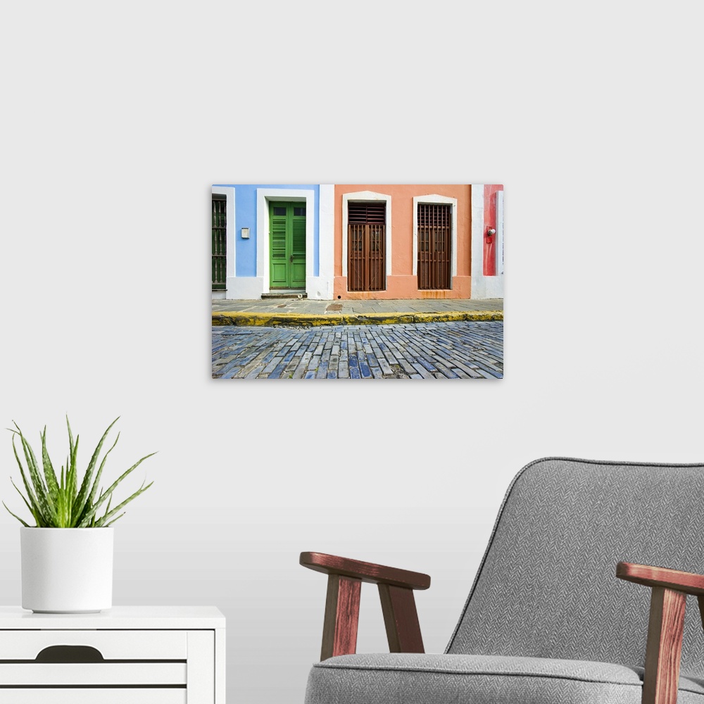 A modern room featuring This is a horizontal photograph of an urban landscape of doorways to colorful houses.