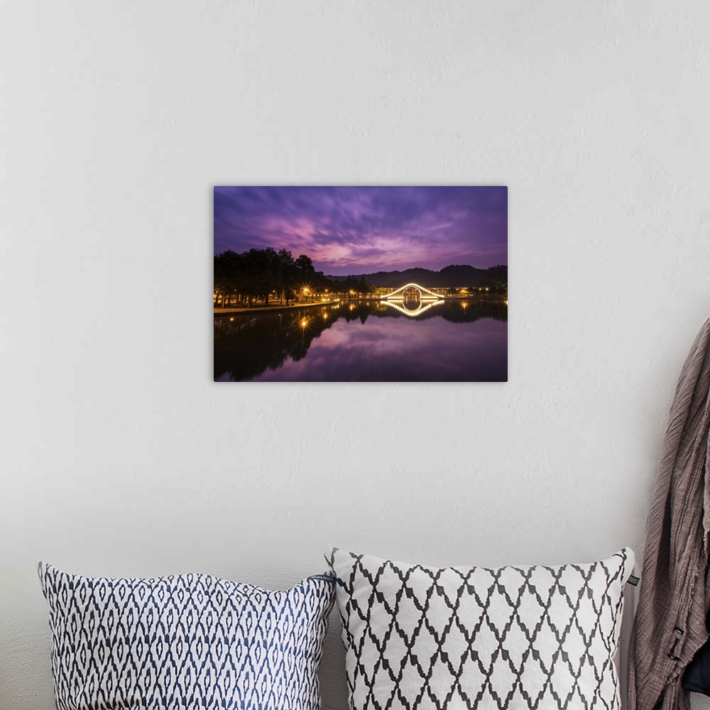 A bohemian room featuring Purple tone prior to sunrise with light up arch bridge and its reflection in the water.