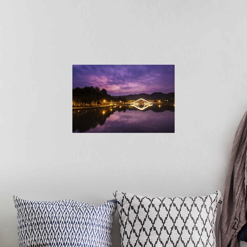 A bohemian room featuring Purple tone prior to sunrise with light up arch bridge and its reflection in the water.