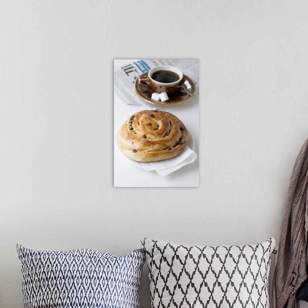 A bohemian room featuring Raisin roll, coffee and newspaper on white background, close-up