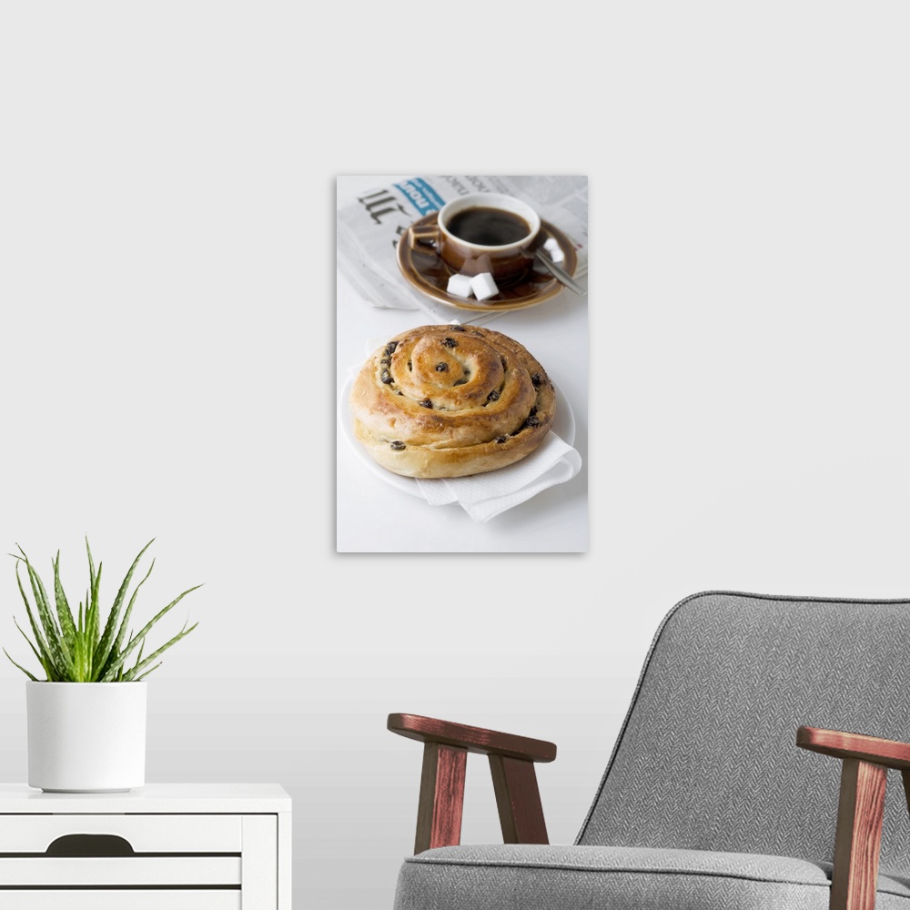 A modern room featuring Raisin roll, coffee and newspaper on white background, close-up