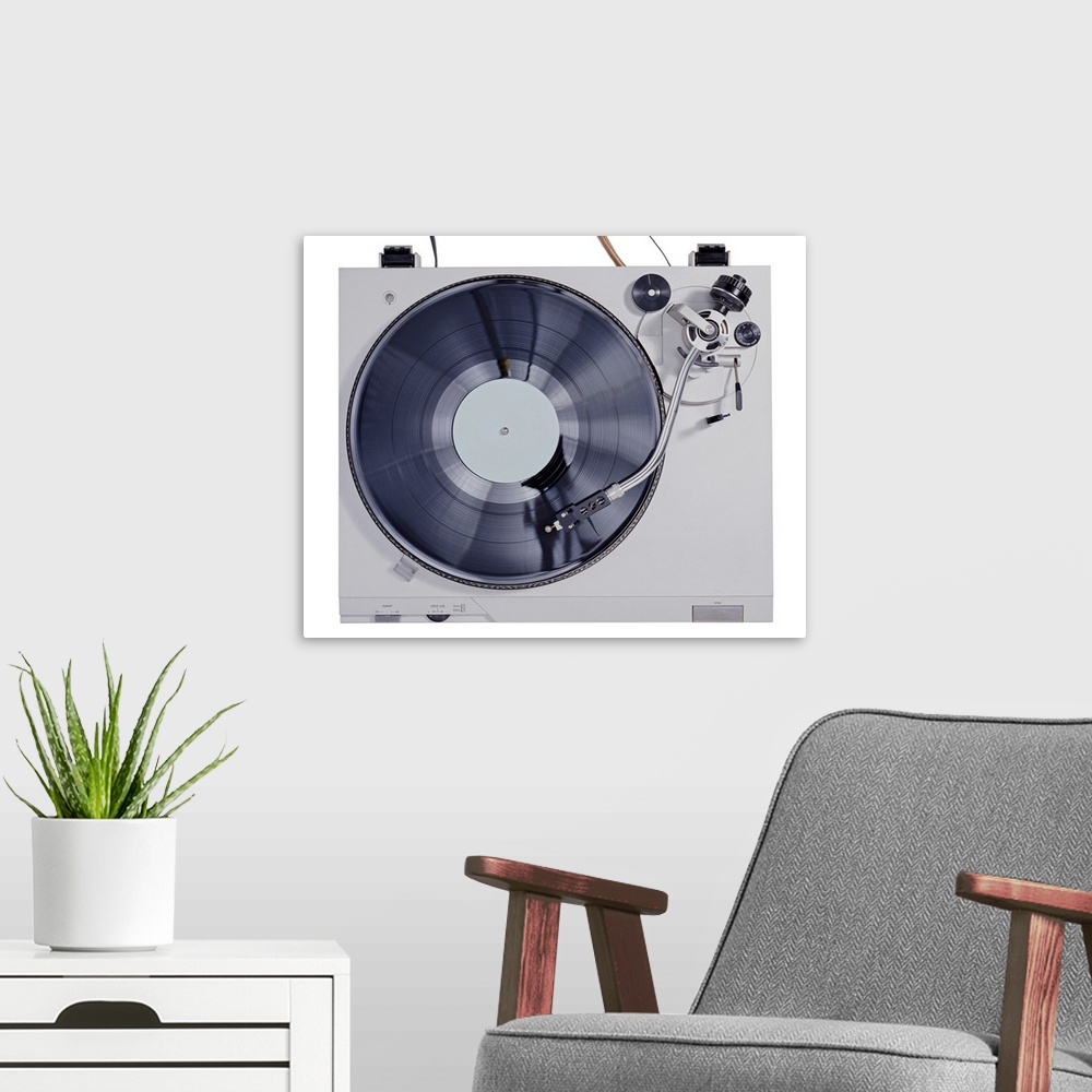 A modern room featuring This photograph is taken of a vintage record player looking down at the record as it plays on the...