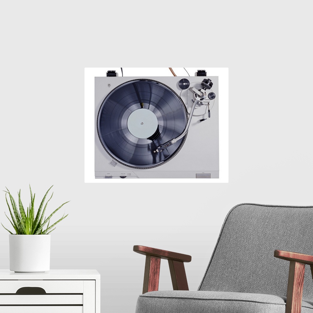 A modern room featuring This photograph is taken of a vintage record player looking down at the record as it plays on the...