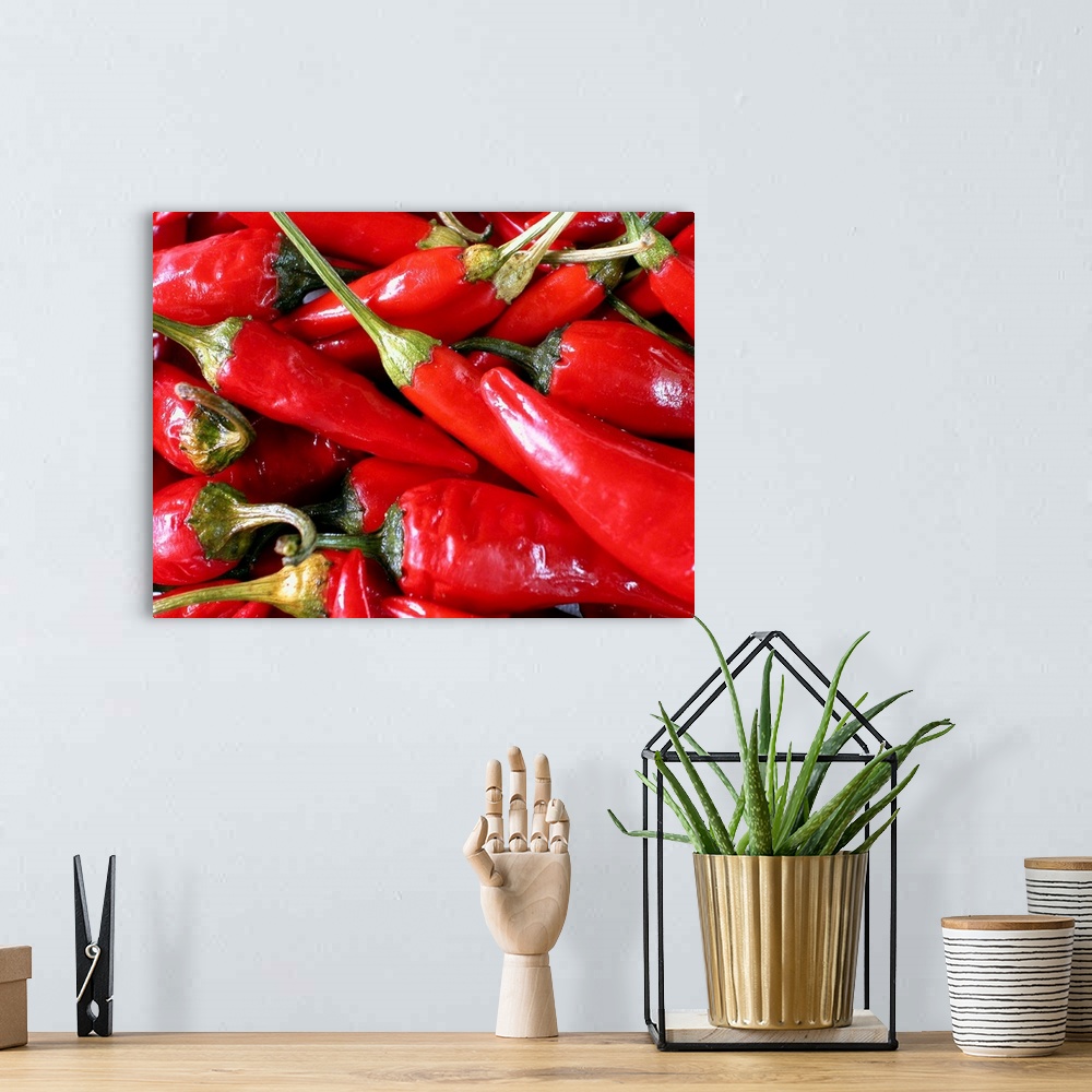 A bohemian room featuring A batch of chili peppers are photographed very closely.