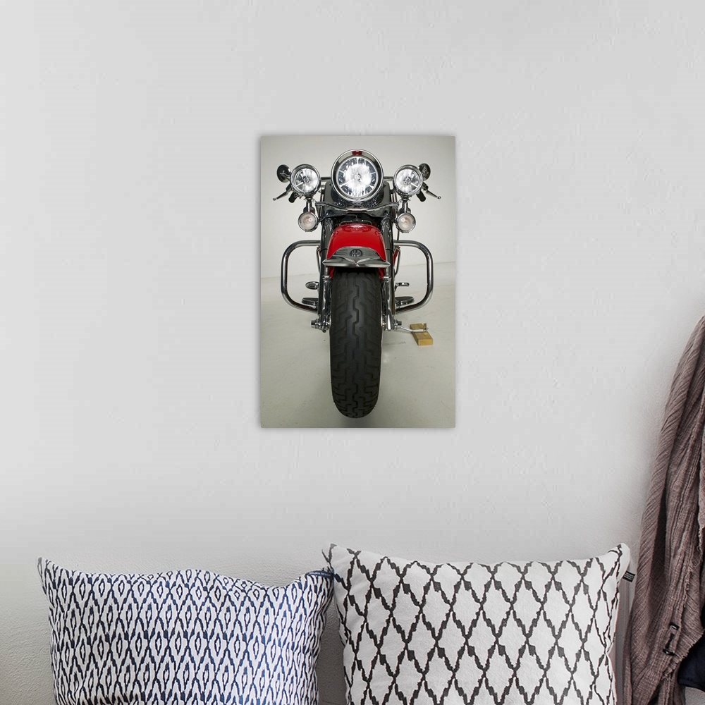 A bohemian room featuring Vertical photo on canvas of a vintage motorcycle seen from the front.