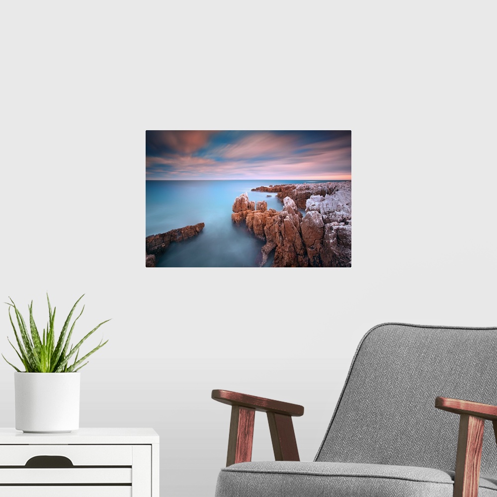 A modern room featuring Rocks in sea at sunset at Cap d'Antibes (French Riviera).