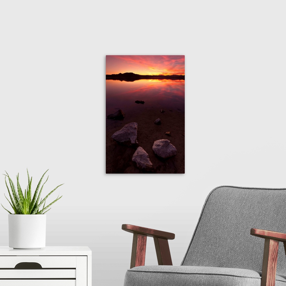 A modern room featuring Rocks on beach at sunset.