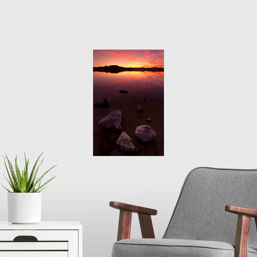 A modern room featuring Rocks on beach at sunset.