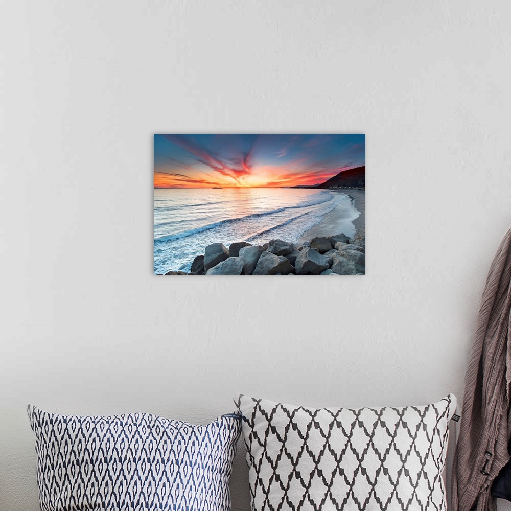 A bohemian room featuring Rocks on sea at sunset.