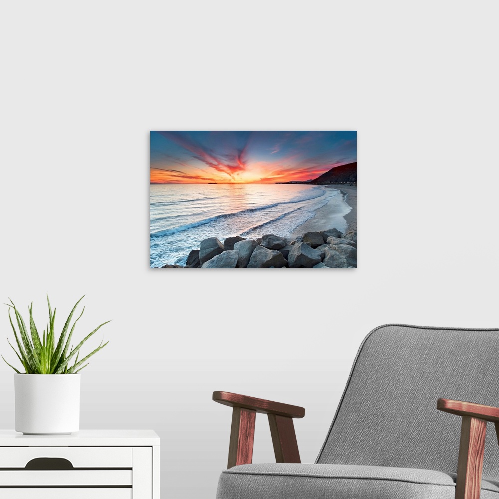 A modern room featuring Rocks on sea at sunset.