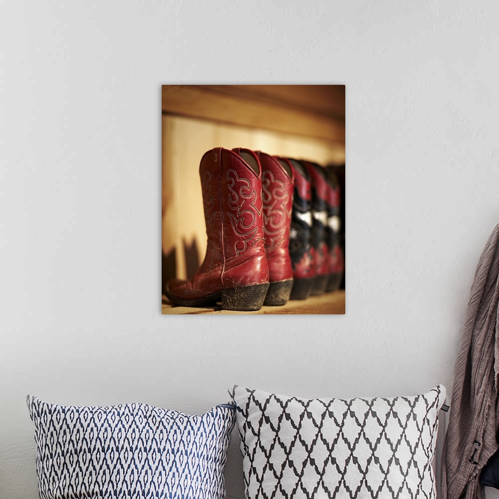 A bohemian room featuring Row of cowboy boots sitting on a shelf