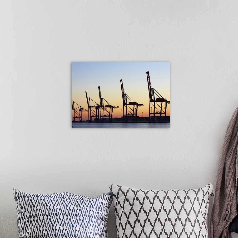 A bohemian room featuring Row of cranes in the dock area of Malaga at sunset