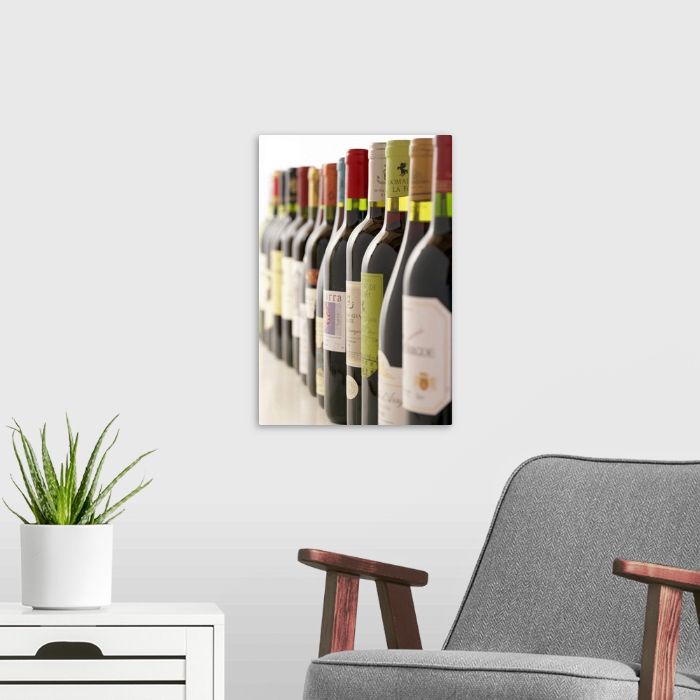 A modern room featuring Artwork perfect for the home or kitchen showing a line of red wine bottles taken at an angle with...