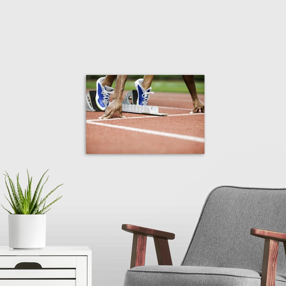 A modern room featuring Large photo on canvas of a track athlete at the starting line about to take off sprinting.