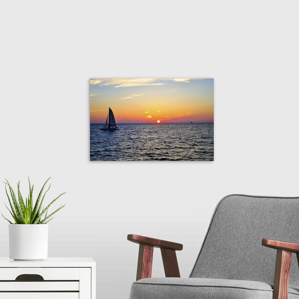 A modern room featuring Sail boat on sea at sunset in Gulf of Mexico.