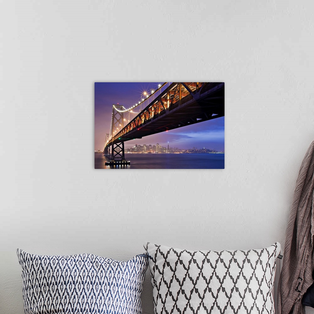 A bohemian room featuring This oversized piece is a photograph taken from below the bridge that is fully lit during the nig...