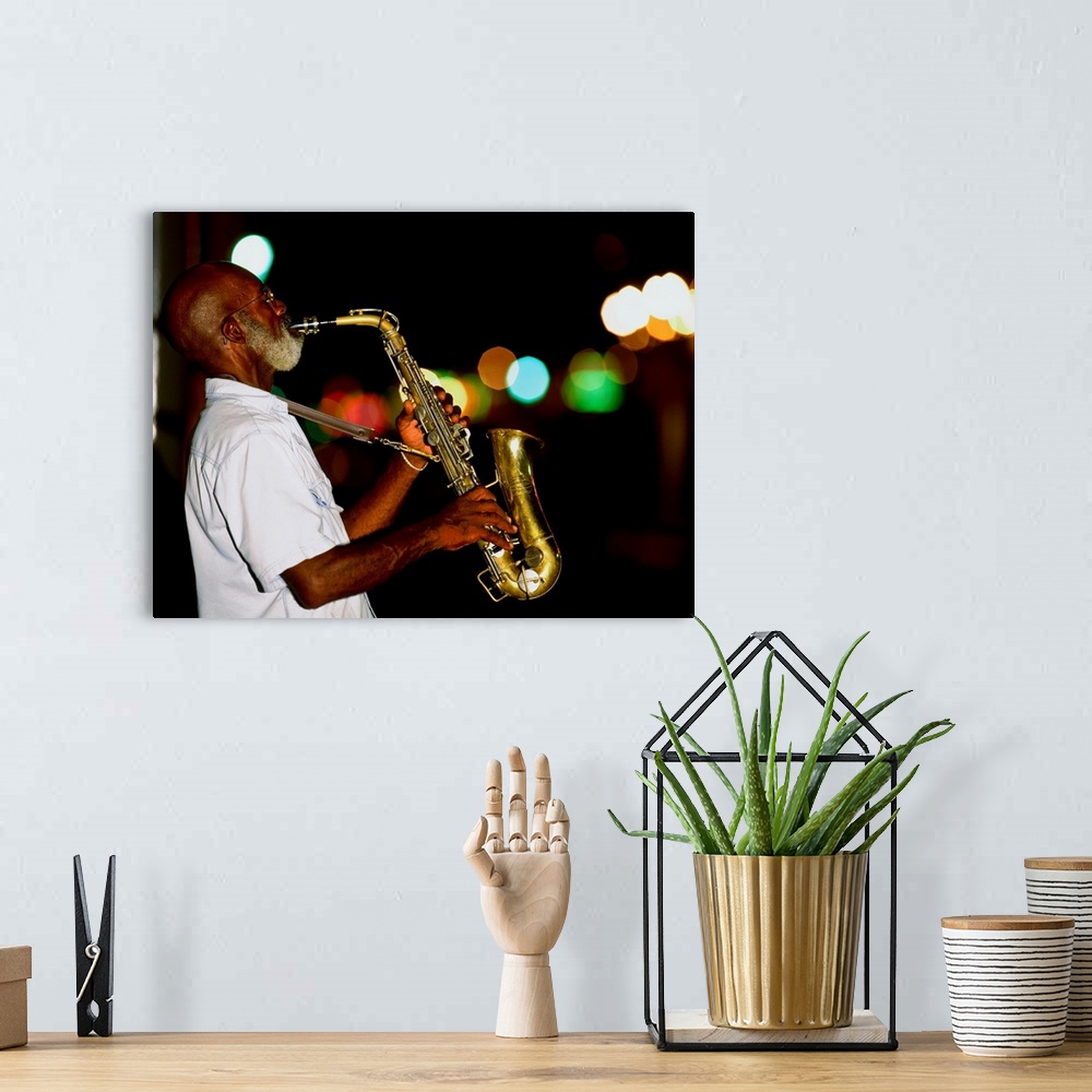A bohemian room featuring Saxophonist on street at night, New Orleans, Louisiana, USA