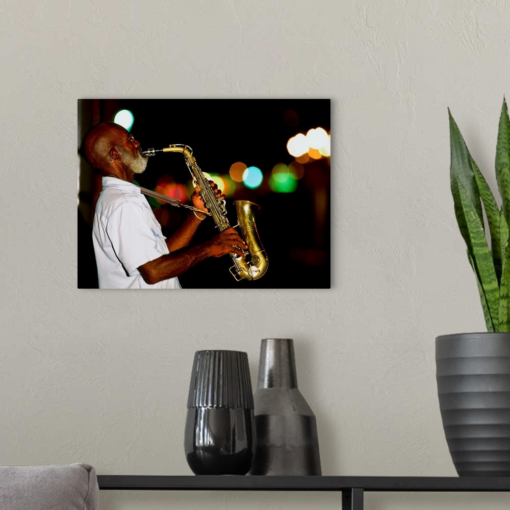 A modern room featuring Saxophonist on street at night, New Orleans, Louisiana, USA