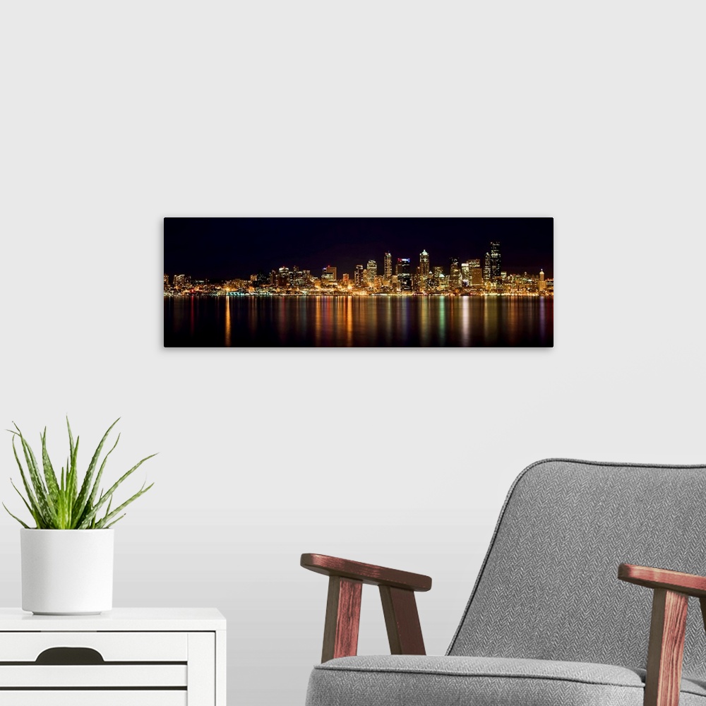 A modern room featuring Nighttime shot of downtown Seattle at night with lights of city reflected in water of Puget Sound.