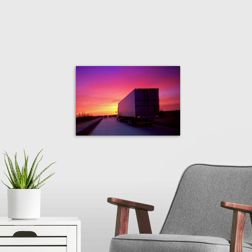 A modern room featuring Semi-truck on road at sunset