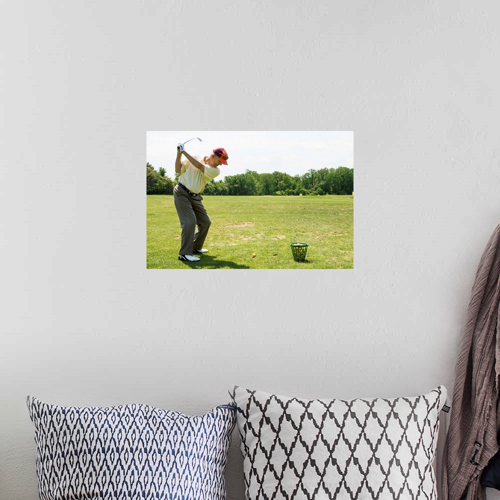 A bohemian room featuring Senior golfer hitting practice balls at a range