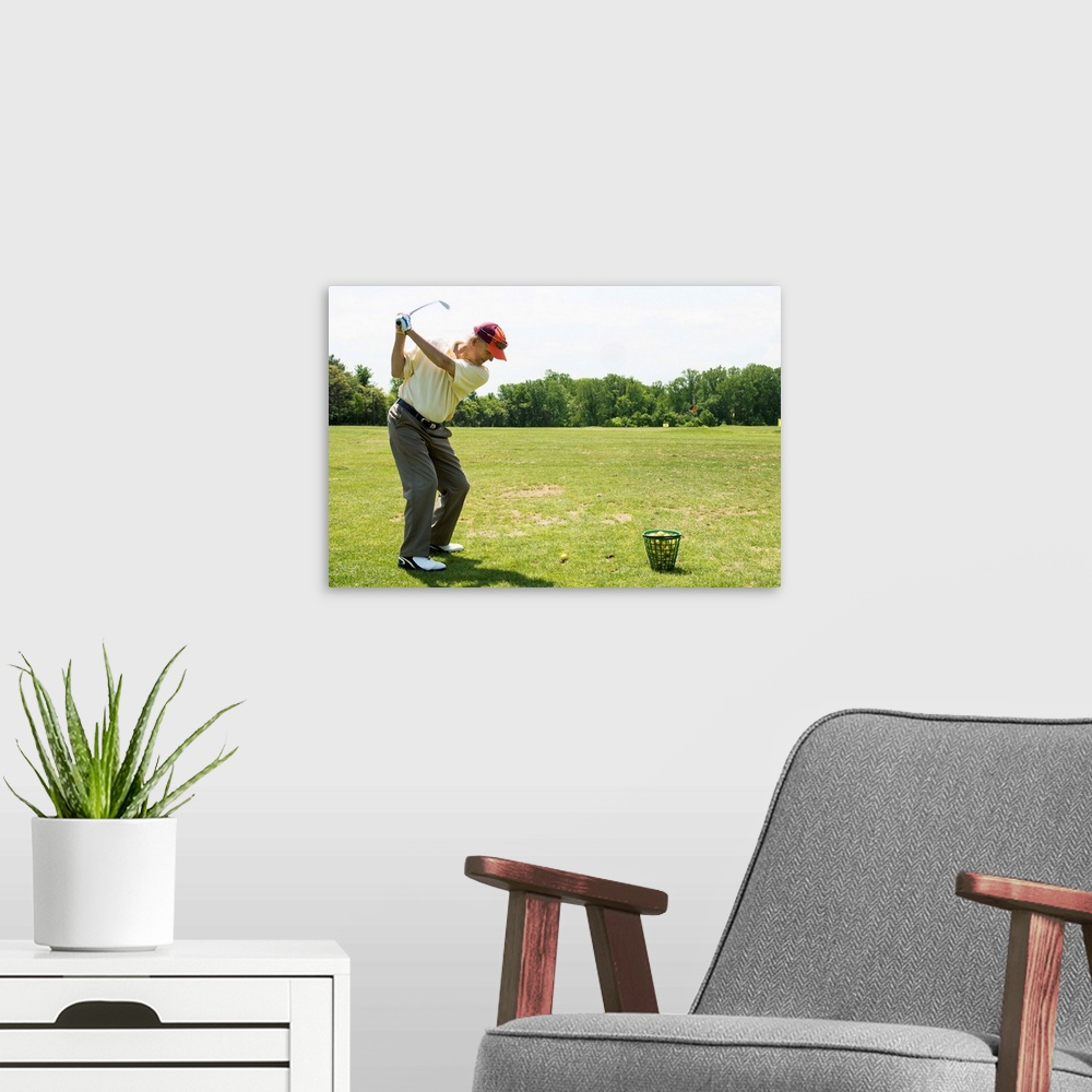 A modern room featuring Senior golfer hitting practice balls at a range