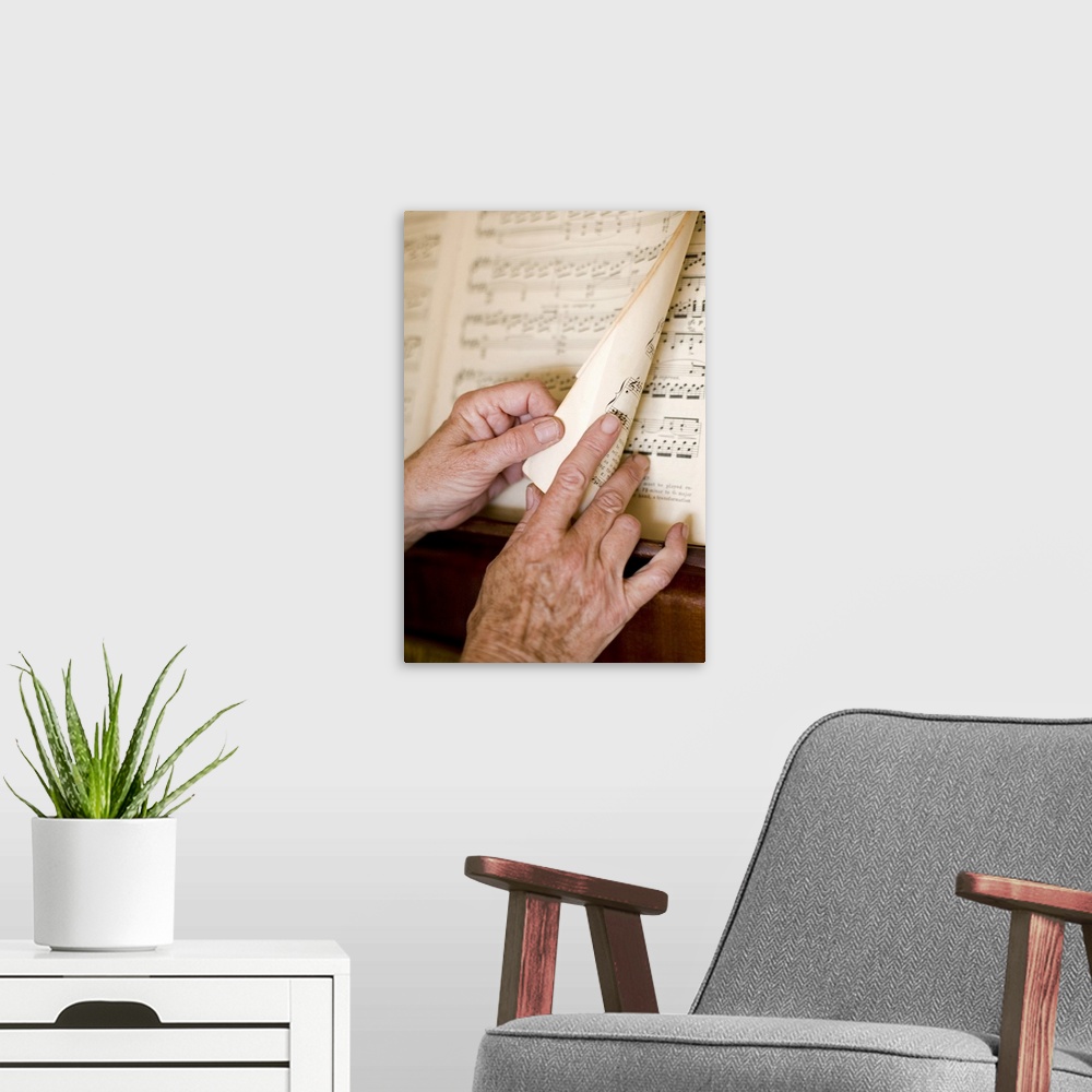 A modern room featuring Senior's hands turning page of sheet music