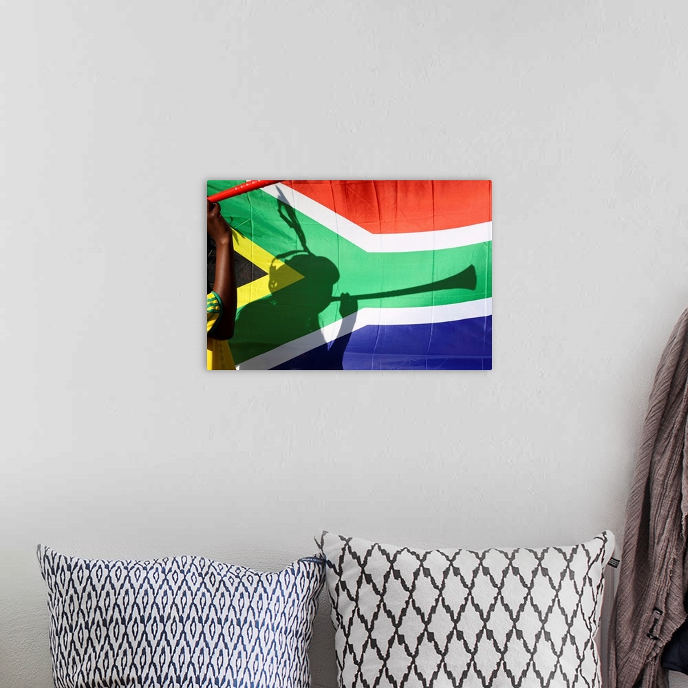 A bohemian room featuring Shadow of soccer supporter blowing vuvuzela, South African flag in background, Johannesburg, Sout...