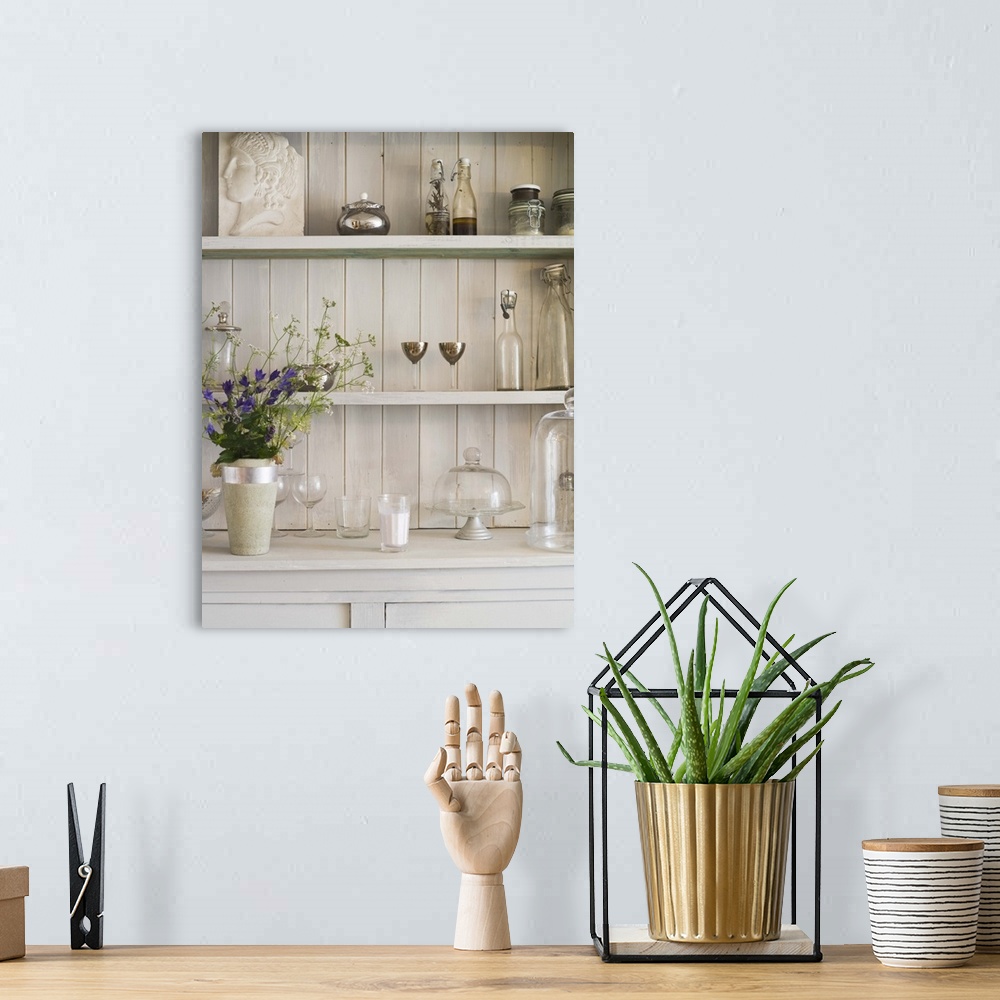 A bohemian room featuring Shelf with flowers and vintage glassware