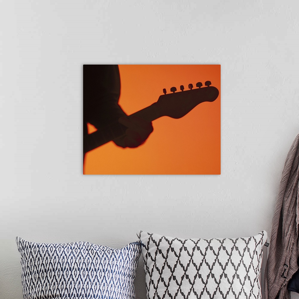 A bohemian room featuring silhouette of a person playing a electric guitar
