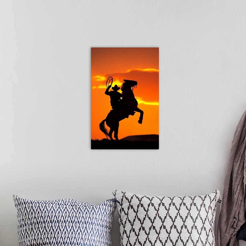 A bohemian room featuring Large artwork of the silhouette of a cowboy on a horse that is standing on it's back two legs in ...