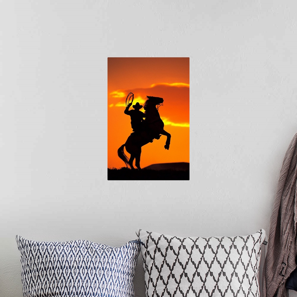A bohemian room featuring Large artwork of the silhouette of a cowboy on a horse that is standing on it's back two legs in ...