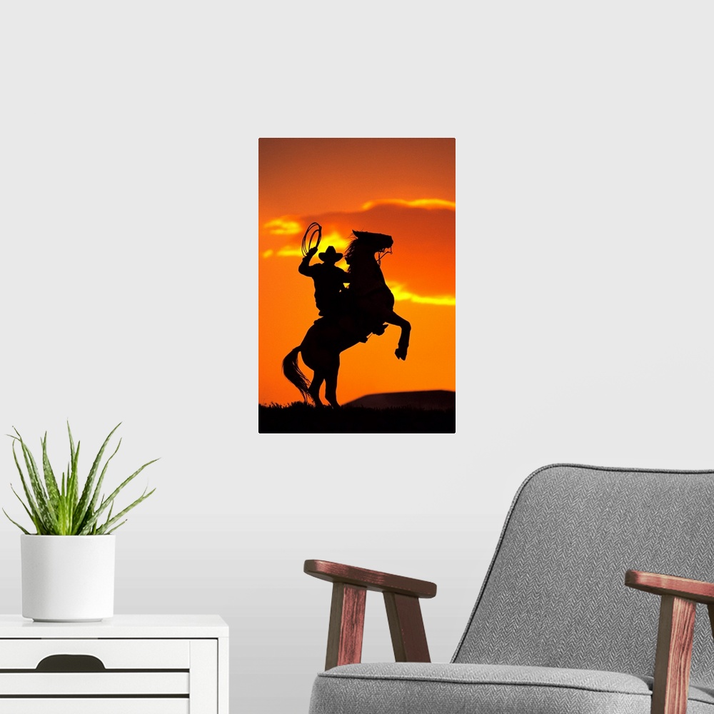 A modern room featuring Large artwork of the silhouette of a cowboy on a horse that is standing on it's back two legs in ...