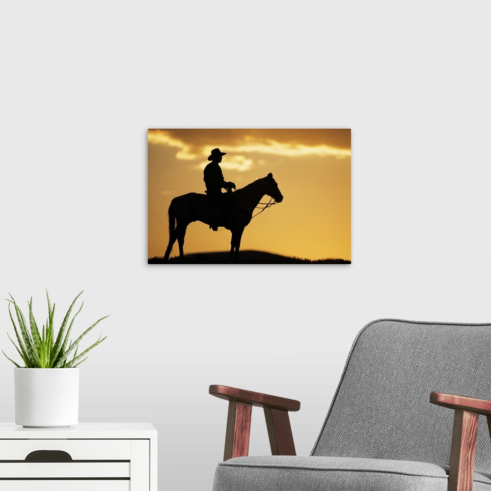 A modern room featuring Silhouette of cowboy on horseback at sunset or sunrise