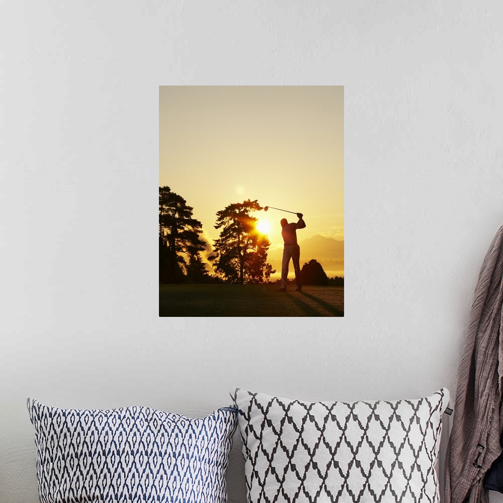 A bohemian room featuring Big, vertical photograph of the setting sun behind trees on a golf course.  The silhouette of a g...