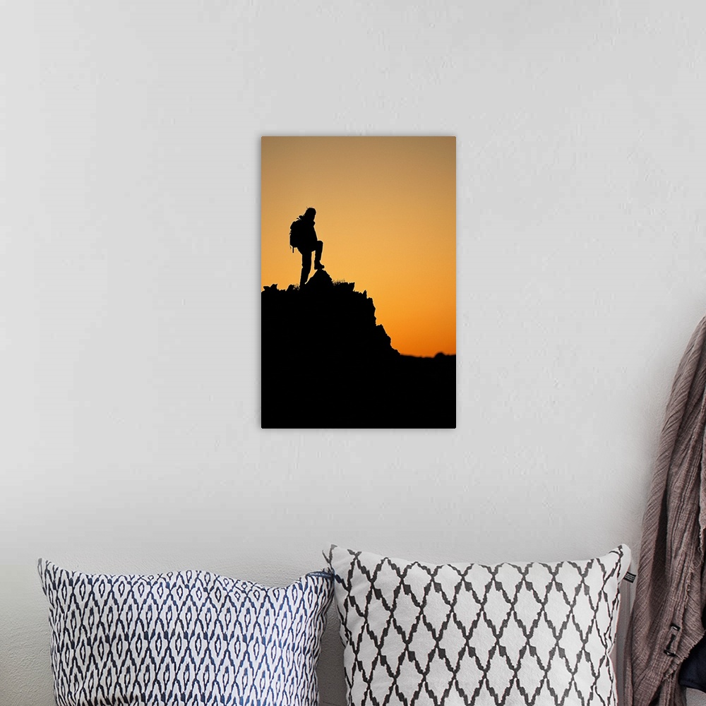 A bohemian room featuring Silhouette of hiker standing on peak at sunset