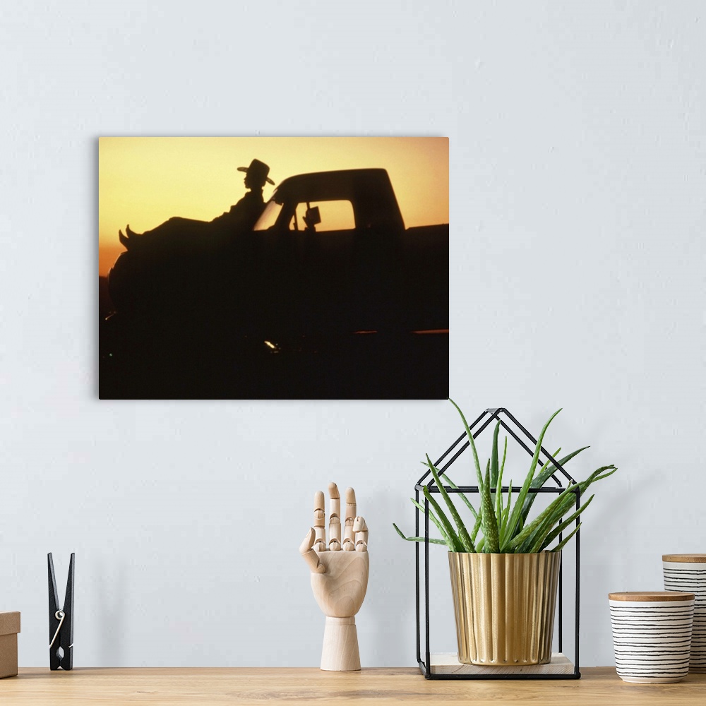 A bohemian room featuring Silhouette of man reclining on hood of truck
