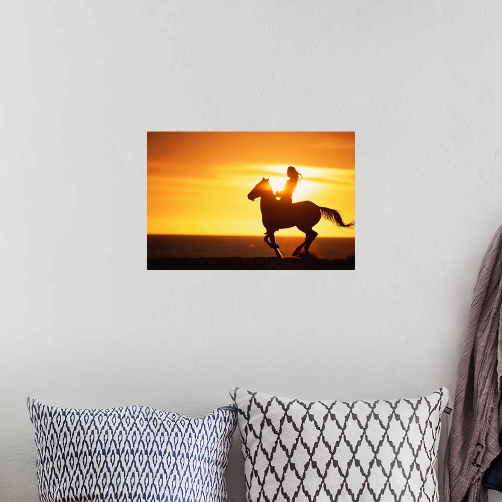A bohemian room featuring Big photo on canvas of a woman riding on a horse silhouetted against a bright setting sun.