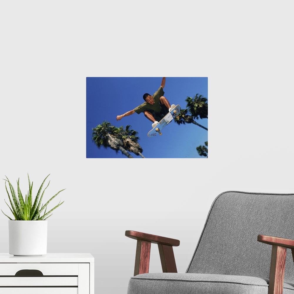 A modern room featuring Skateboarder in mid-jump, low angle view