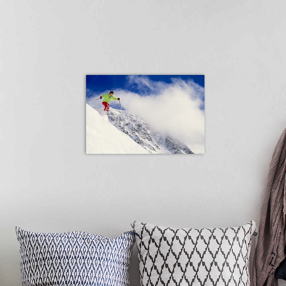 A bohemian room featuring Photograph of man on skis coming down snowy slope with huge mountain in background under a cloudy...