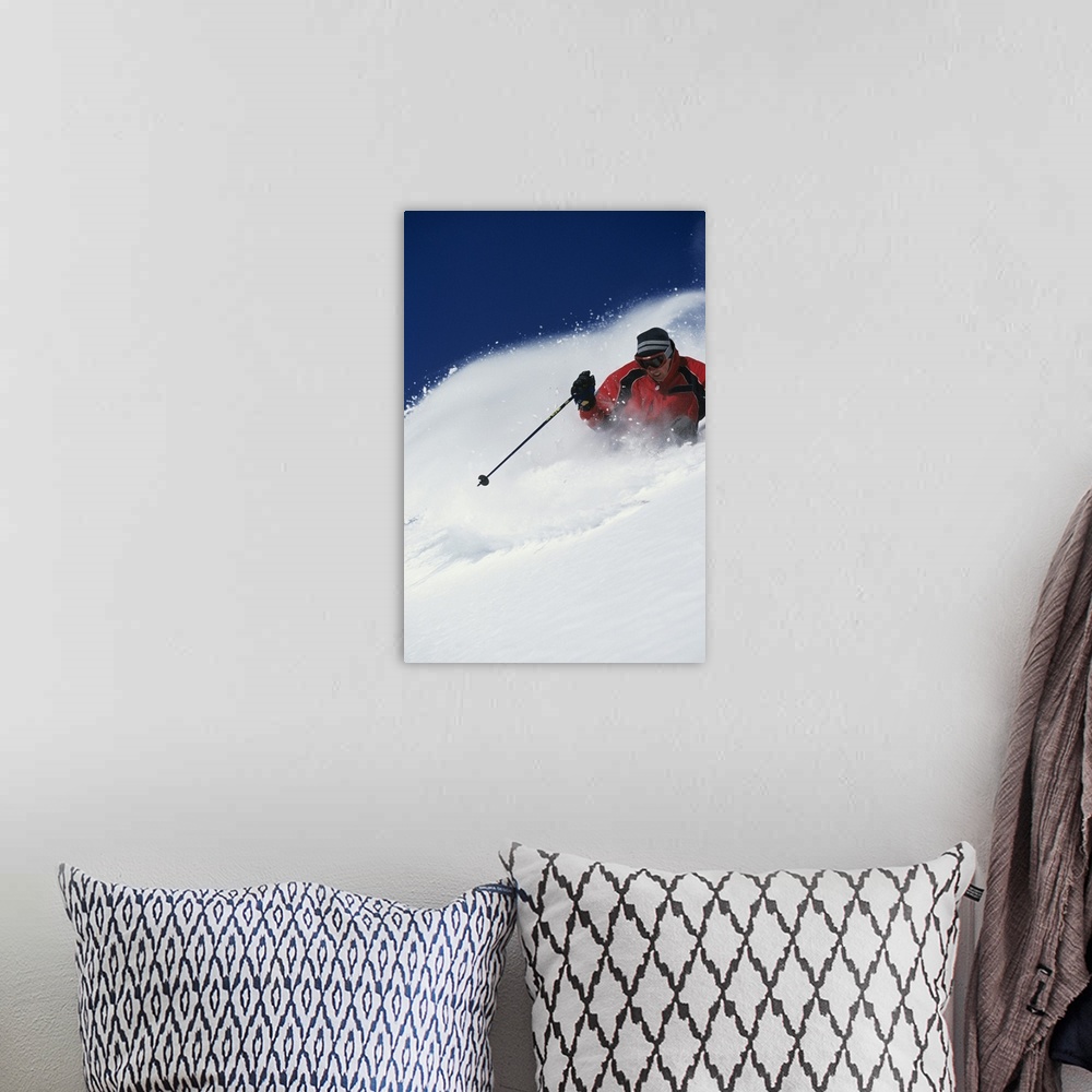 A bohemian room featuring A big vertical piece of a skier coming down a mountain with snow flying up as he skis side to side.