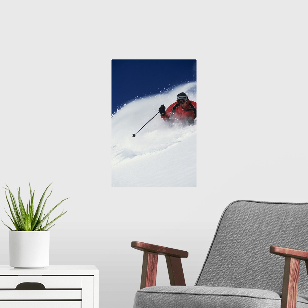 A modern room featuring A big vertical piece of a skier coming down a mountain with snow flying up as he skis side to side.
