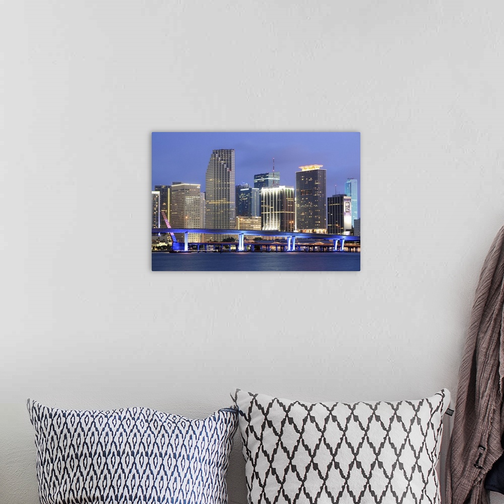 A bohemian room featuring Large canvas photo art of the Miami cityscape lit up at night along the waterfront.