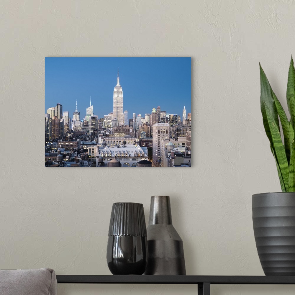 A modern room featuring Skyline of Midtown Manhattan with Empire State Building at dusk