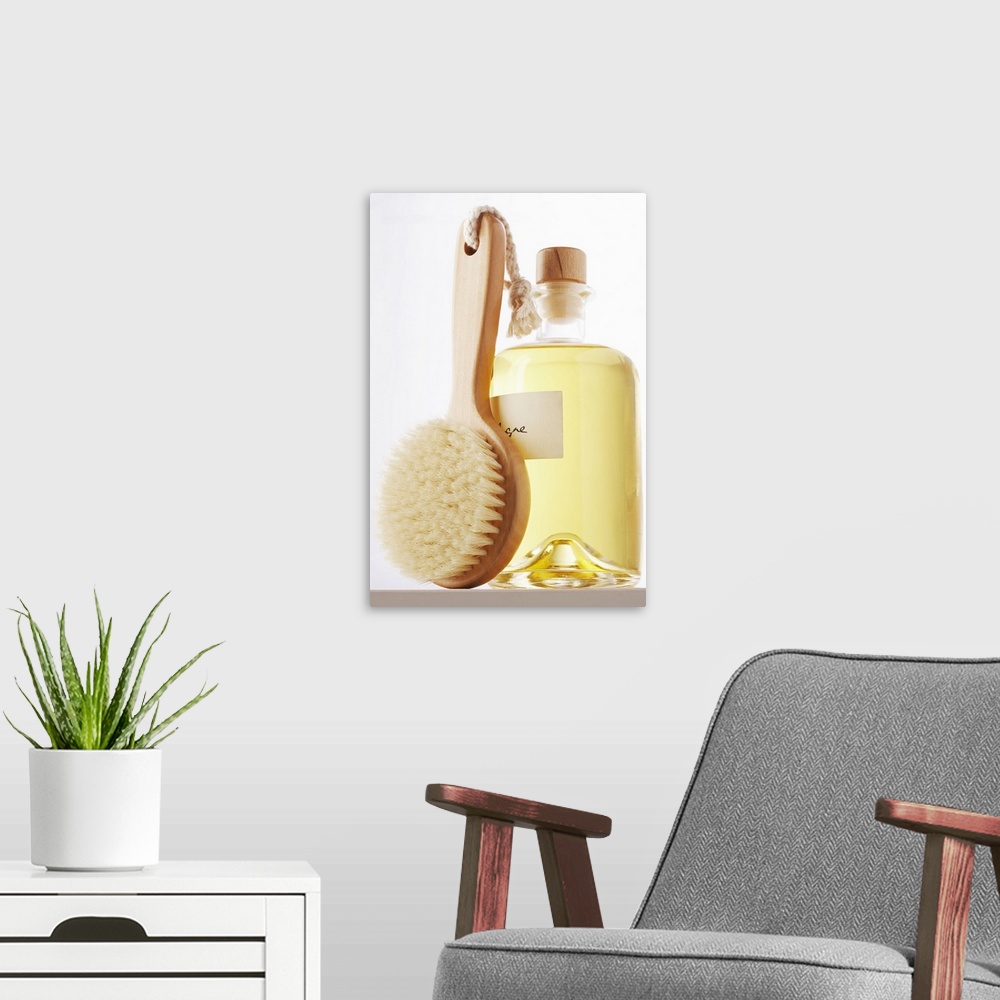 A modern room featuring Small bath brush leaning against jar of eau de cologne, close-up