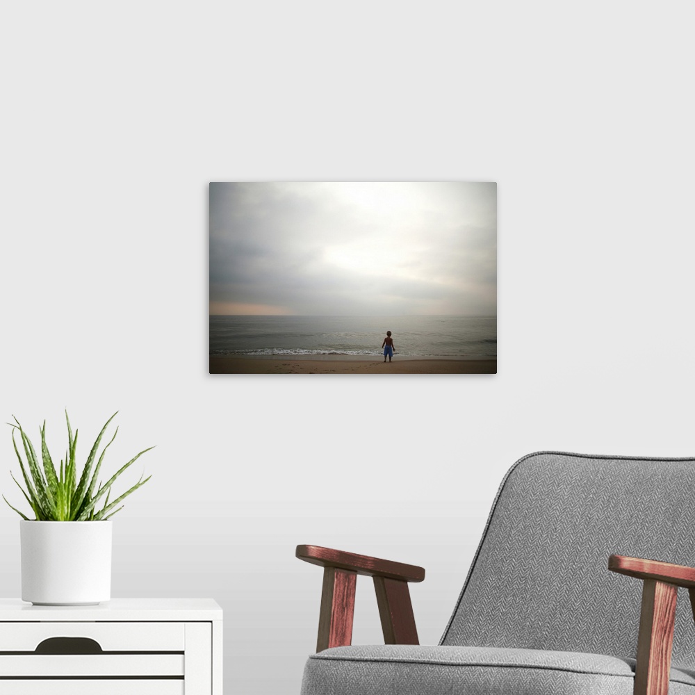 A modern room featuring Small boy looking at sky and ocean